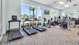 Fully equipped fitness center in clubhouse with views onto pool area