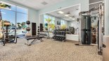 Fully equipped fitness center in clubhouse with views onto pool area