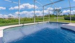 view of pool with orange grove and golf course beyond from Monticello 1 Villa for rent in Orlando