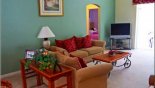 Living room with large flat screen TV and direct access to pool deck from Highlands Reserve rental Villa direct from owner