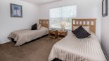 Twin bedroom 3 with views onto pool deck and woodland beyond from Highlands Reserve rental Villa direct from owner