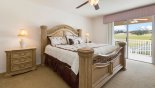 Master bedroom with king sized bed and private balcony with golf course views from Monticello 13 Villa for rent in Orlando