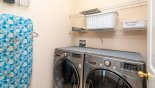 Laundry room with stainless steel front loading washer & dryer with this Orlando Villa for rent direct from owner