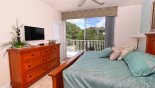 Master bedroom with flat screen TV and access to private balcony with this Orlando Townhouse for rent direct from owner