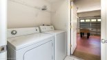 Laundry room with washer, dryer, iron & ironing board - door leads to games room with this Orlando Villa for rent direct from owner