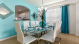 Dining area with glass topped dining table & 8 chairs - www.iwantavilla.com is the best in Orlando vacation Villa rentals