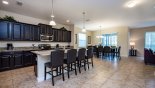 View of kitchen from entrance hallway showing breakfast bar & 4 chairs from Majesty Palm 2 Villa for rent in Orlando