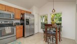 Villa rentals near Disney direct with owner, check out the View of the kitchen, showing the large fridge with ice-maker with table and seating for 3