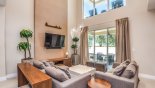 Living room with cathedral ceiling viewed towards covered lanai & private balcony above with this Orlando Townhouse for rent direct from owner
