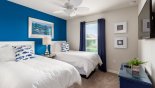 Ensuite bedroom #2 with twin beds , wall-mounted LCD cable TV & views over the pool from Castaway 3 Townhouse for rent in Orlando