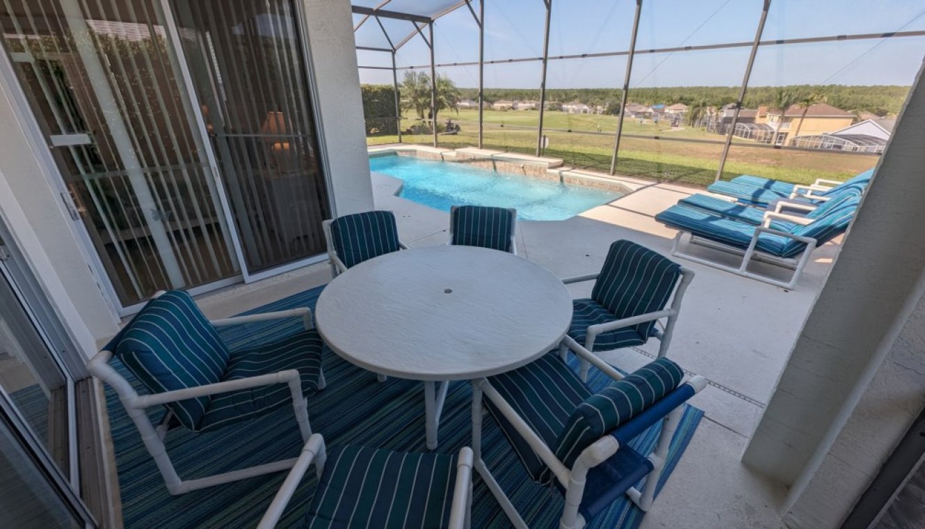 View from covered lanai towards pool and golf course beyond