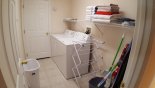 Laundry room opposite kitchen with washer, dryer, iron & ironing board from Wynnewood 3 Villa for rent in Orlando