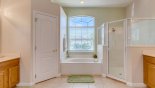 Master ensuite bathroom #1 with bath, walk-in shower, dual sinks & separate WC with this Orlando Villa for rent direct from owner
