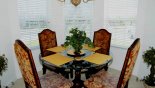 Breakfast nook with glass topped round table with 4 chairs - 3 ways views onto front gardens from Seville 2 Villa for rent in Orlando