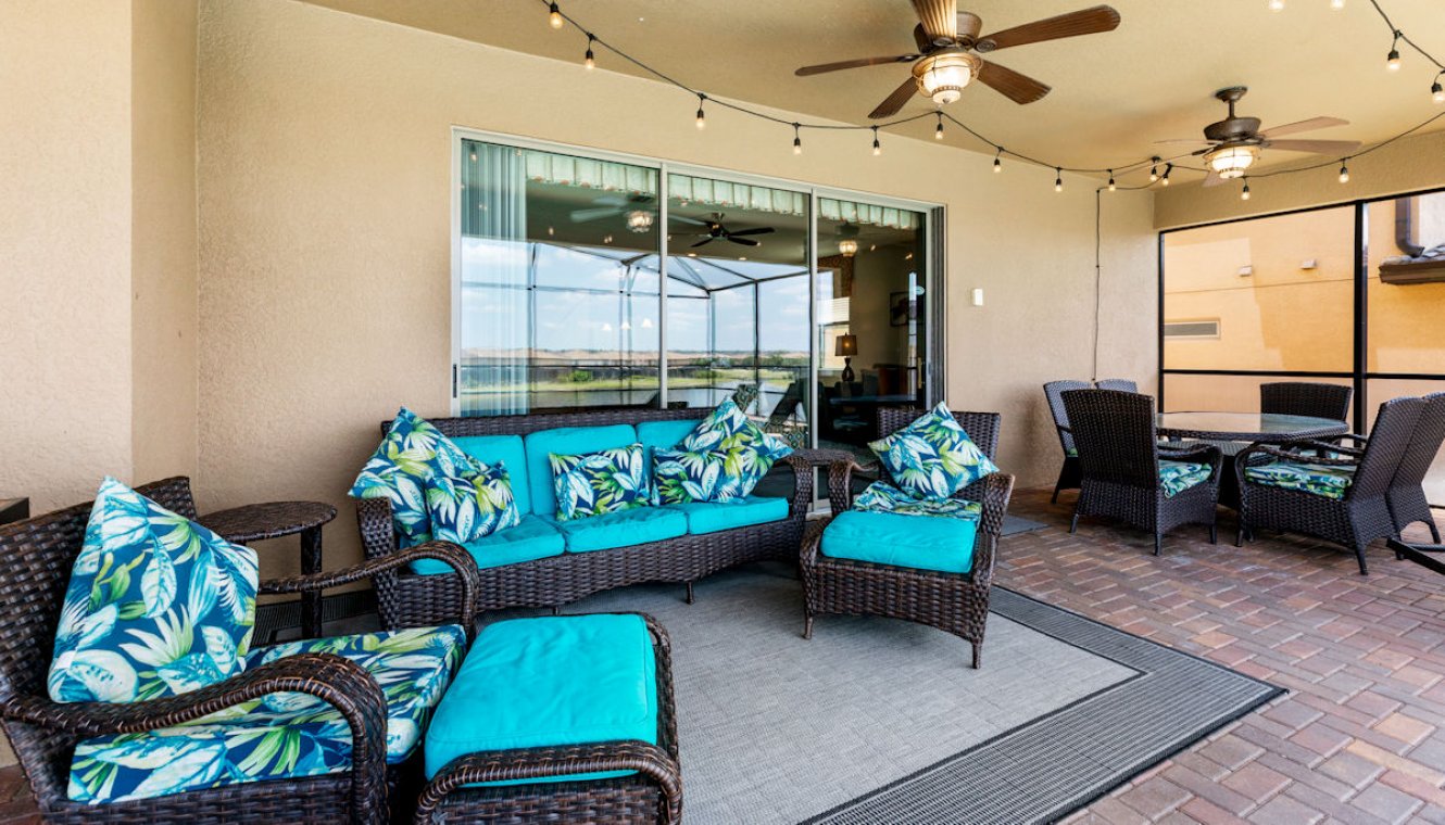 Covered lanai with soft seating area and outdoor dining space